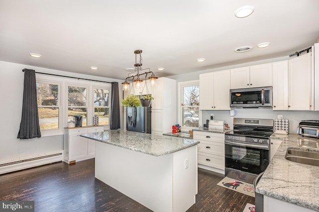 kitchen featuring white cabinets, dark wood-style flooring, appliances with stainless steel finishes, and a center island