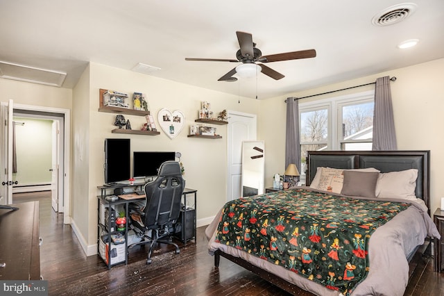 bedroom featuring visible vents, wood finished floors, attic access, and a baseboard radiator