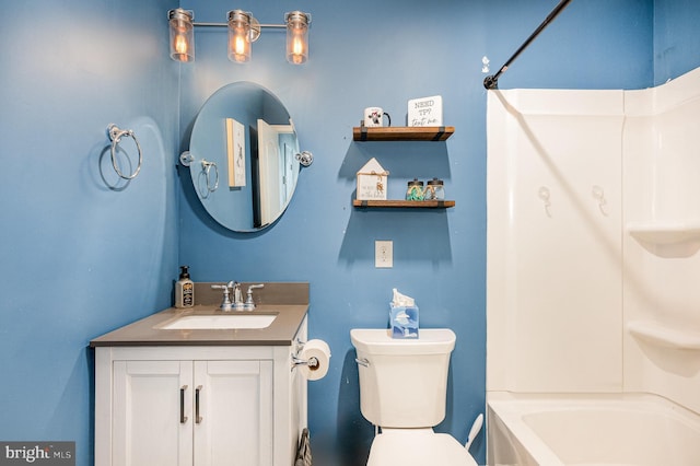 bathroom with toilet, vanity, and  shower combination