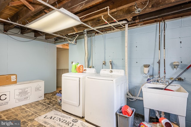 laundry room with washer and clothes dryer, laundry area, and a sink