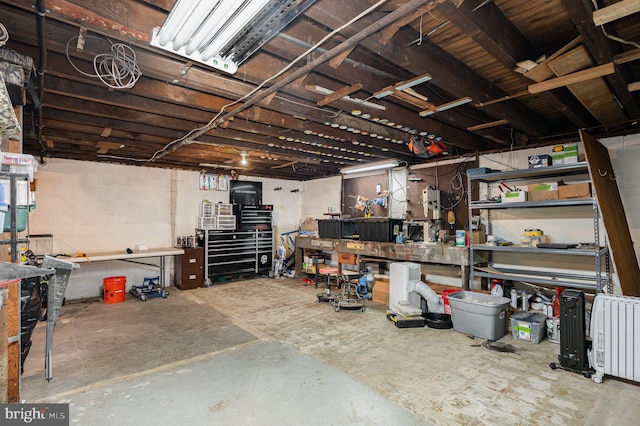 basement featuring a workshop area and concrete block wall