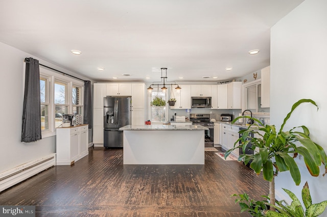 kitchen with dark wood-style floors, stainless steel appliances, white cabinets, a toaster, and a baseboard radiator