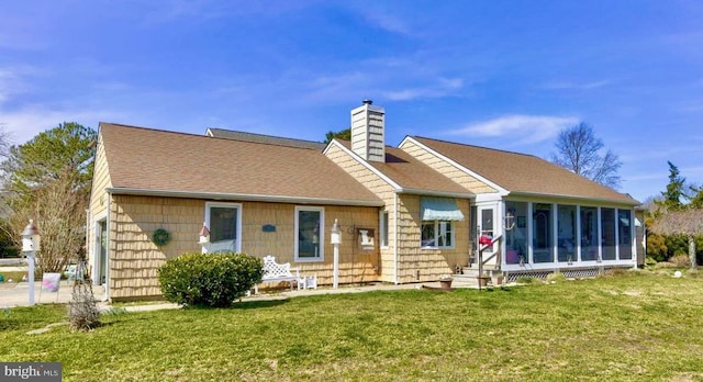 back of house with a shingled roof, a lawn, a chimney, and a sunroom