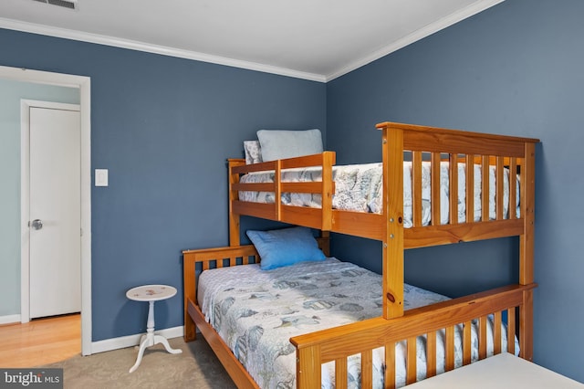 bedroom with visible vents, baseboards, and ornamental molding
