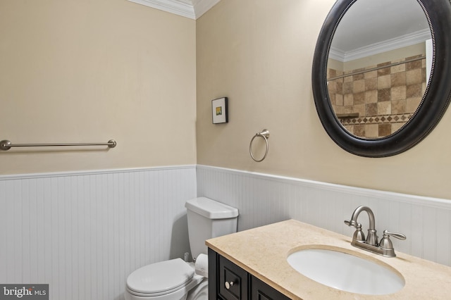 bathroom featuring vanity, ornamental molding, toilet, and wainscoting