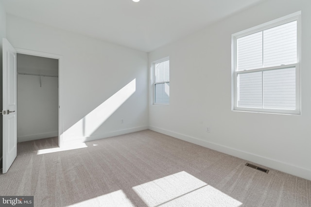 unfurnished bedroom featuring carpet, a closet, visible vents, and baseboards