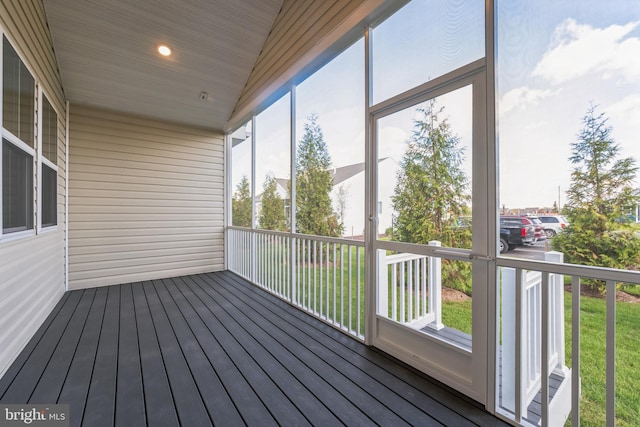 unfurnished sunroom featuring vaulted ceiling