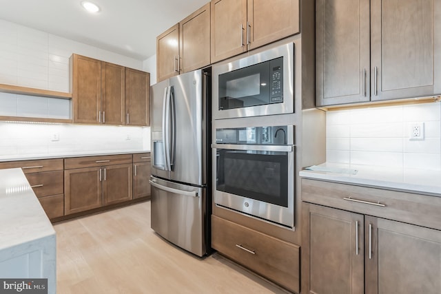 kitchen with open shelves, tasteful backsplash, recessed lighting, appliances with stainless steel finishes, and light wood-style floors