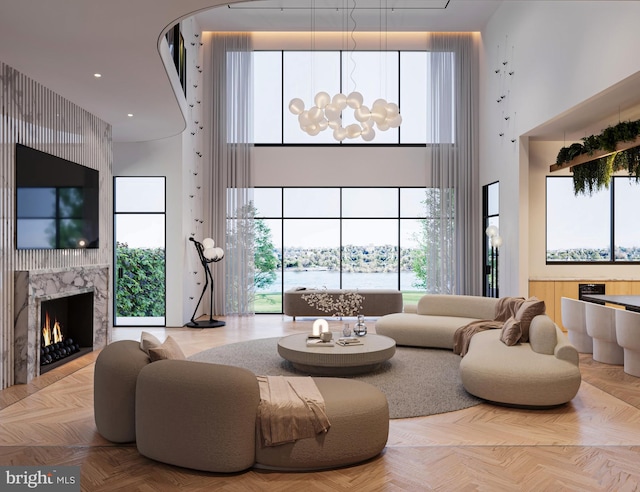 living room featuring a notable chandelier, a high ceiling, a fireplace, and recessed lighting