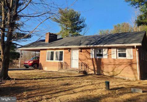 back of house with a carport and a chimney