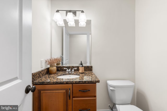 half bathroom featuring toilet and vanity