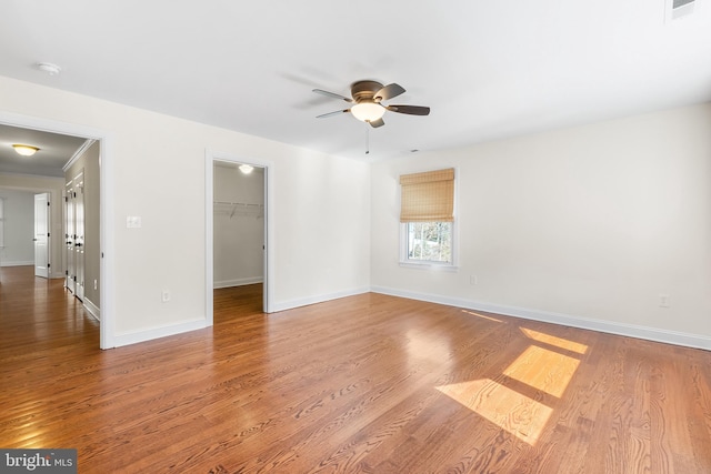 interior space with a closet, a spacious closet, baseboards, and wood finished floors