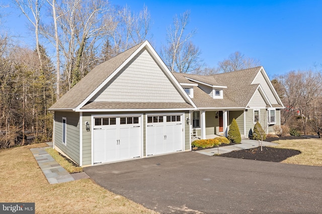 view of front of property with a garage, aphalt driveway, roof with shingles, covered porch, and a front lawn