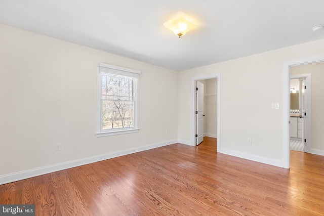 spare room featuring light wood finished floors and baseboards