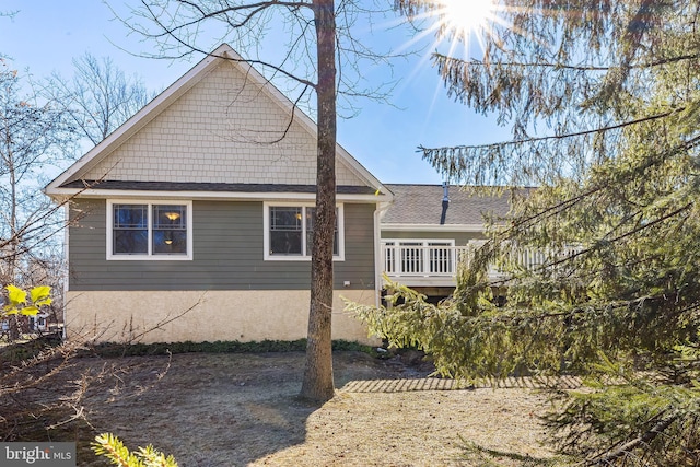 view of side of home with roof with shingles