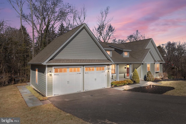 view of front of property with an attached garage, a shingled roof, and aphalt driveway