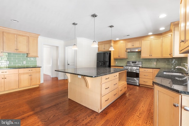 kitchen featuring dark wood finished floors, freestanding refrigerator, light brown cabinetry, a sink, and gas stove