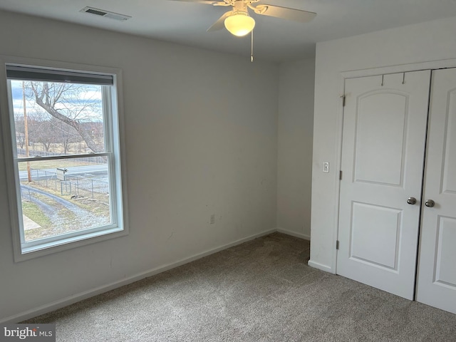 unfurnished bedroom featuring baseboards, visible vents, ceiling fan, carpet flooring, and a closet