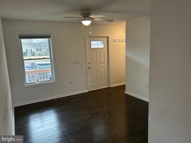 entryway featuring dark wood-type flooring, a ceiling fan, visible vents, and baseboards