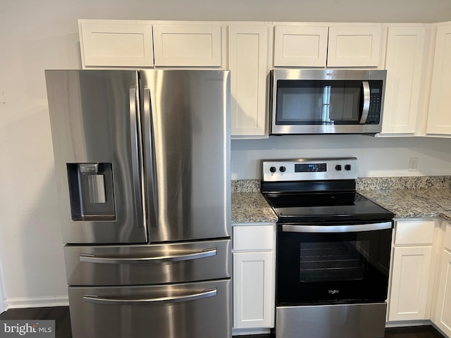 kitchen with appliances with stainless steel finishes, light stone countertops, and white cabinets