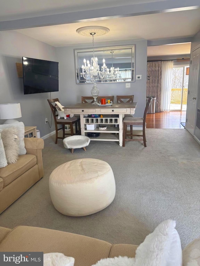 living area with a notable chandelier, baseboards, and carpet