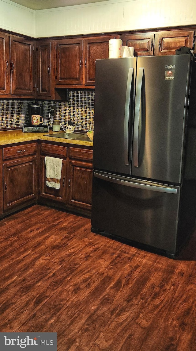 kitchen with tasteful backsplash, dark wood finished floors, and freestanding refrigerator