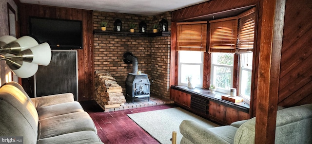 living area featuring a wood stove, wooden walls, and wood finished floors