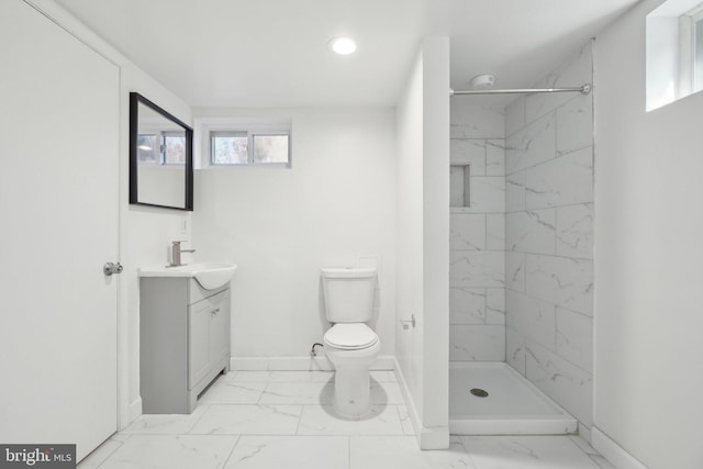 bathroom with vanity, toilet, marble finish floor, and a marble finish shower