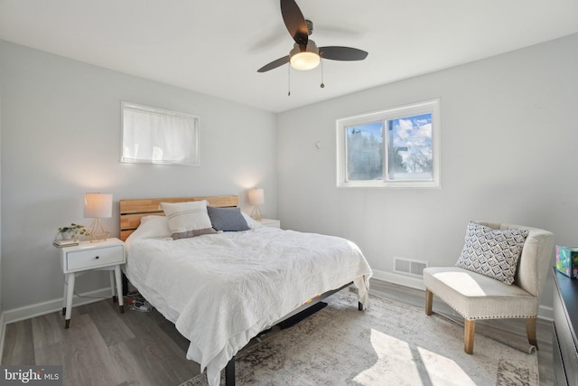 bedroom with visible vents, baseboards, and wood finished floors