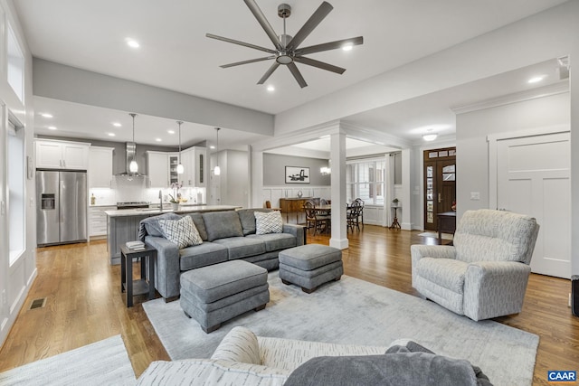 living room featuring light wood finished floors, visible vents, recessed lighting, and a ceiling fan