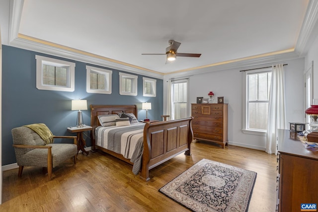 bedroom featuring crown molding, light wood-style flooring, baseboards, and ceiling fan