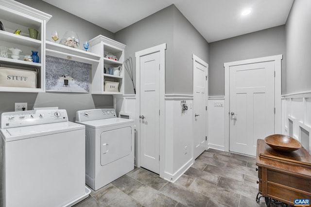 laundry area featuring washing machine and clothes dryer, laundry area, and a wainscoted wall