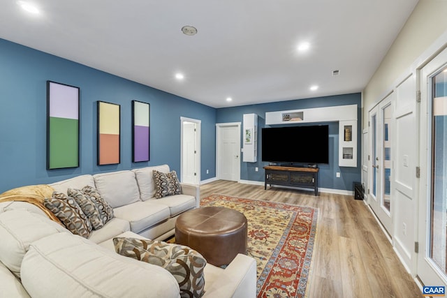 living area with recessed lighting, visible vents, baseboards, and light wood finished floors