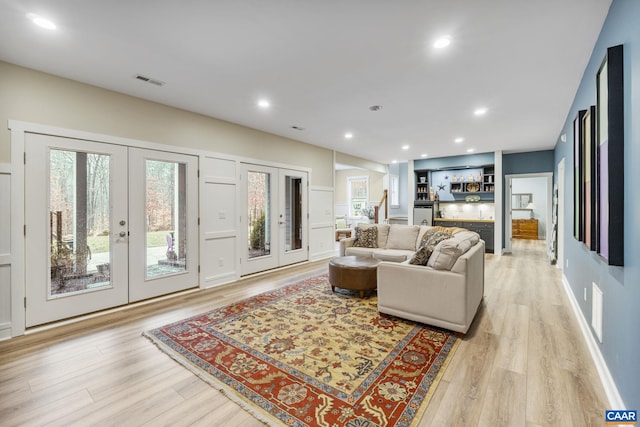 living room featuring visible vents, recessed lighting, french doors, and light wood-type flooring