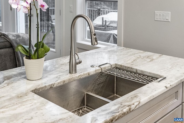 details featuring light stone counters and a sink