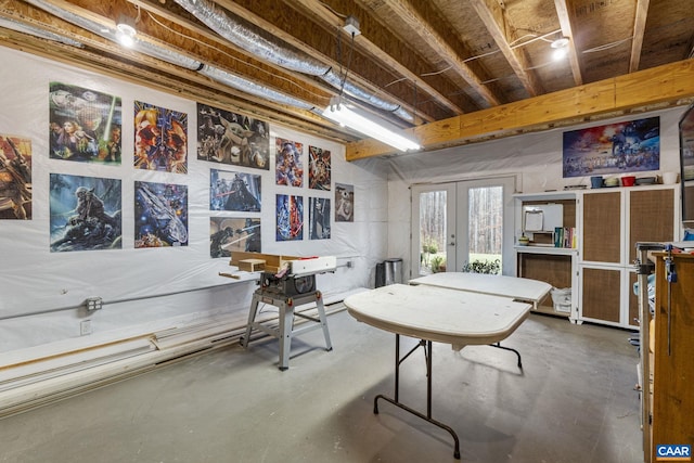 rec room featuring french doors and finished concrete flooring