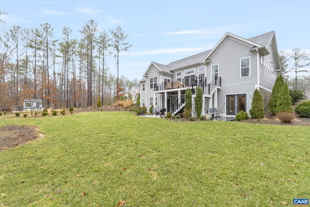 view of home's exterior featuring a patio area, a lawn, stairs, and a deck