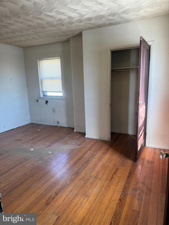 unfurnished bedroom with a closet and wood-type flooring