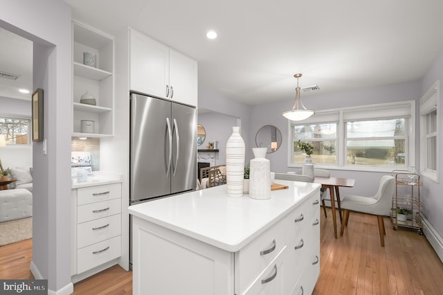 kitchen featuring open shelves, visible vents, light wood-style flooring, white cabinets, and stainless steel fridge