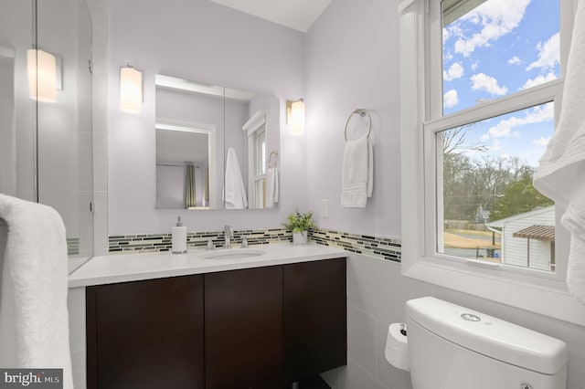 bathroom with toilet, backsplash, and vanity