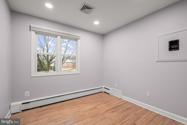 spare room featuring baseboards, visible vents, a baseboard radiator, wood finished floors, and recessed lighting