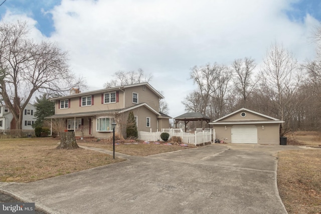 view of front of property with concrete driveway, a chimney, fence, an outdoor structure, and a front lawn