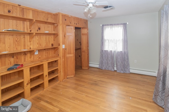 bedroom with light wood-type flooring and a baseboard heating unit