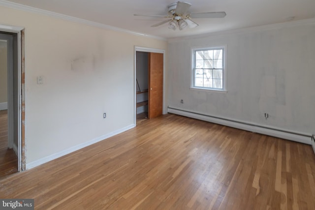 spare room with baseboards, light wood finished floors, a baseboard radiator, and crown molding