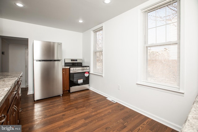 kitchen featuring recessed lighting, stainless steel appliances, baseboards, light stone countertops, and dark wood-style floors