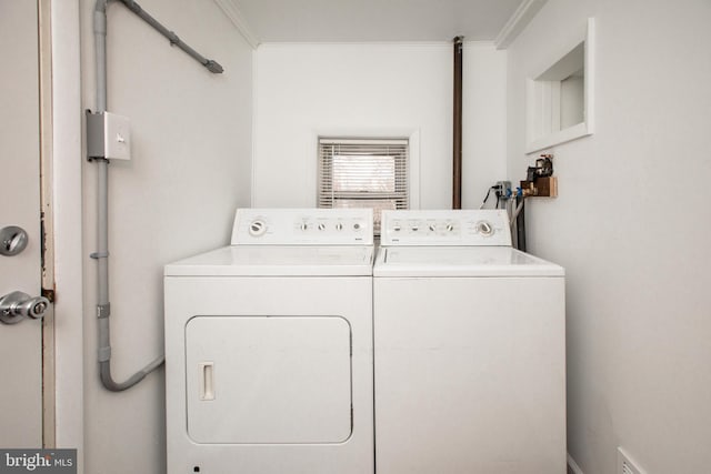 laundry room featuring laundry area, washer and clothes dryer, and crown molding