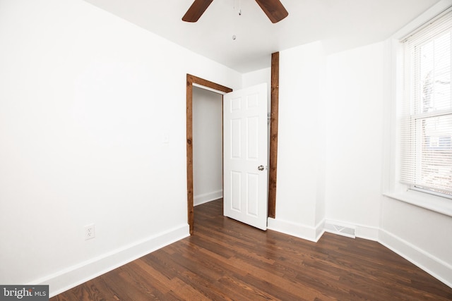 interior space featuring dark wood-type flooring, a wealth of natural light, visible vents, and baseboards