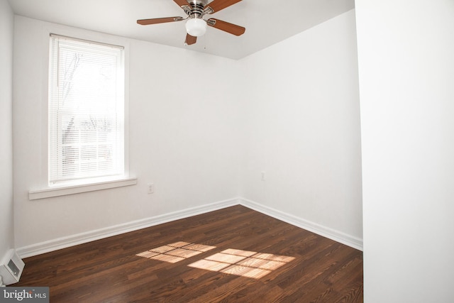 empty room with ceiling fan, dark wood-type flooring, visible vents, and baseboards