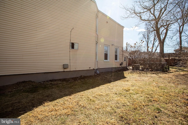 view of property exterior with a lawn and fence