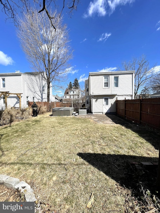 view of yard with a jacuzzi, a fenced backyard, and a patio